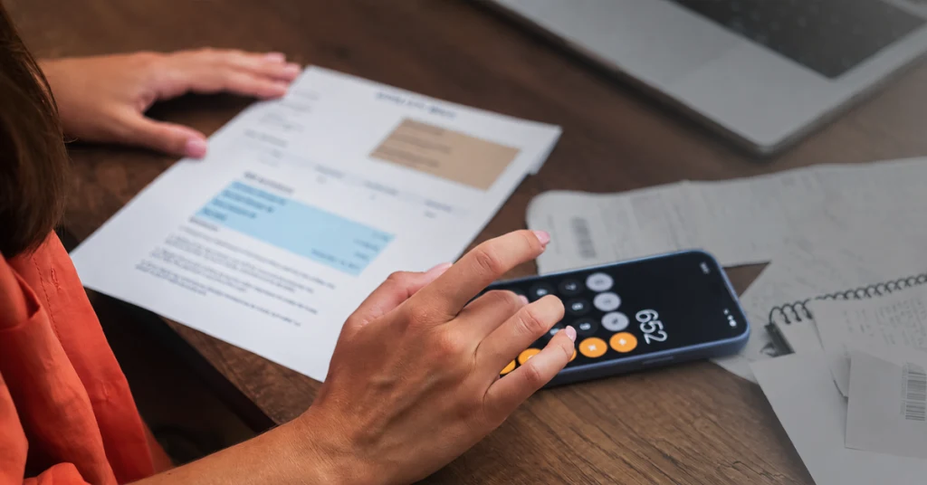 Person using a calculator to calculate costs.
